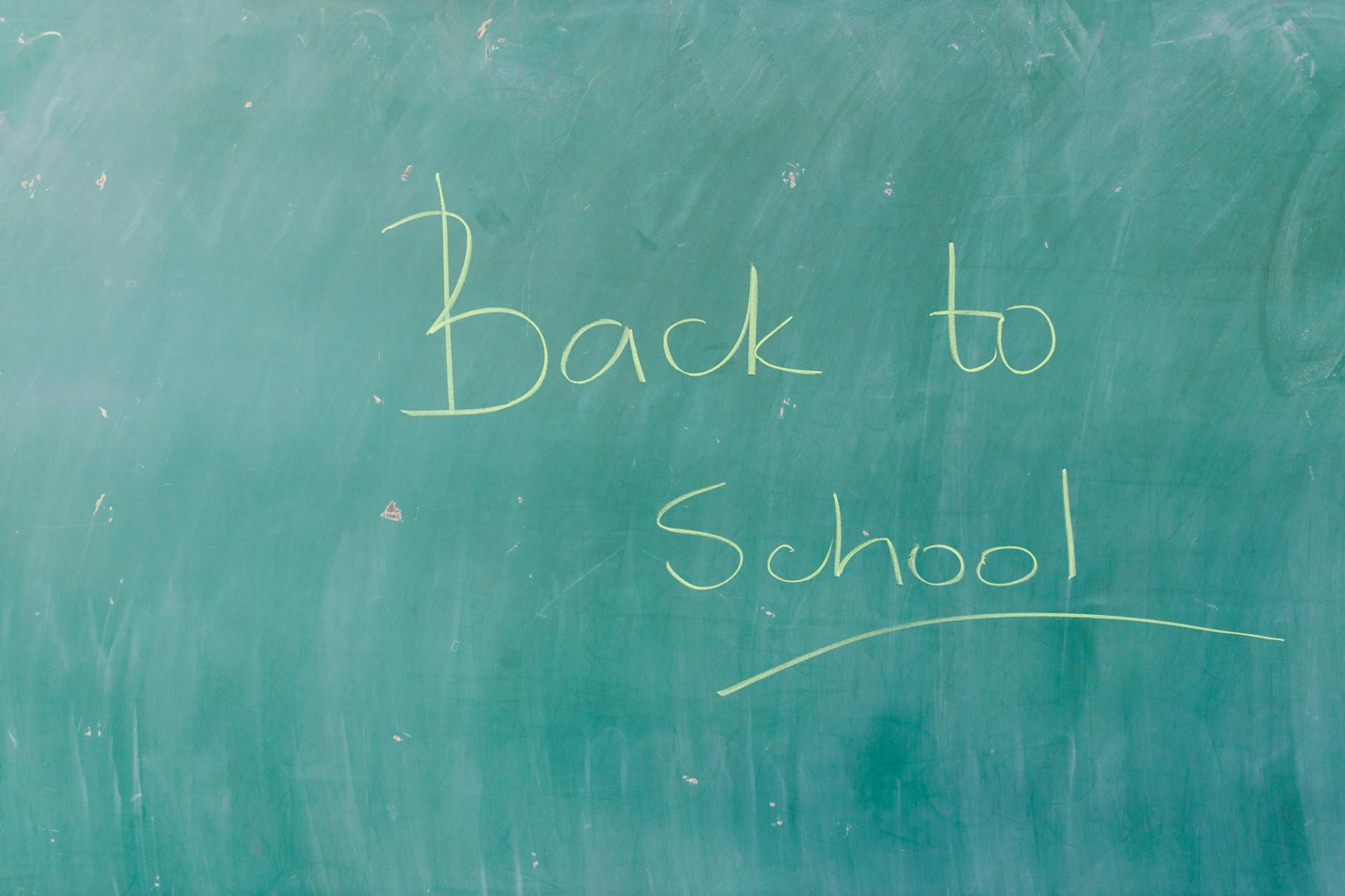Zielona szkolna tablica z napisem Back to School wykonanym kredą