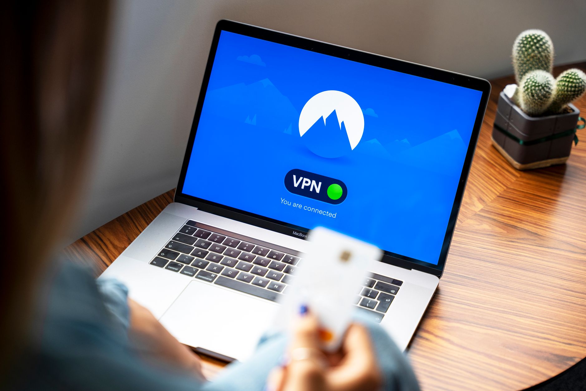 Osoba korzystająca z VPN na laptopie w nowoczesnym wnętrzu