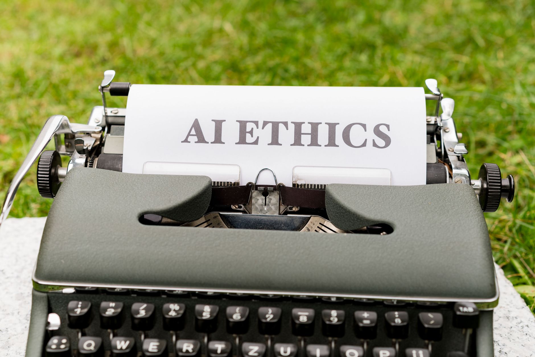 Zabytkowa maszyna do pisania na zewnątrz z kartką AI ethics