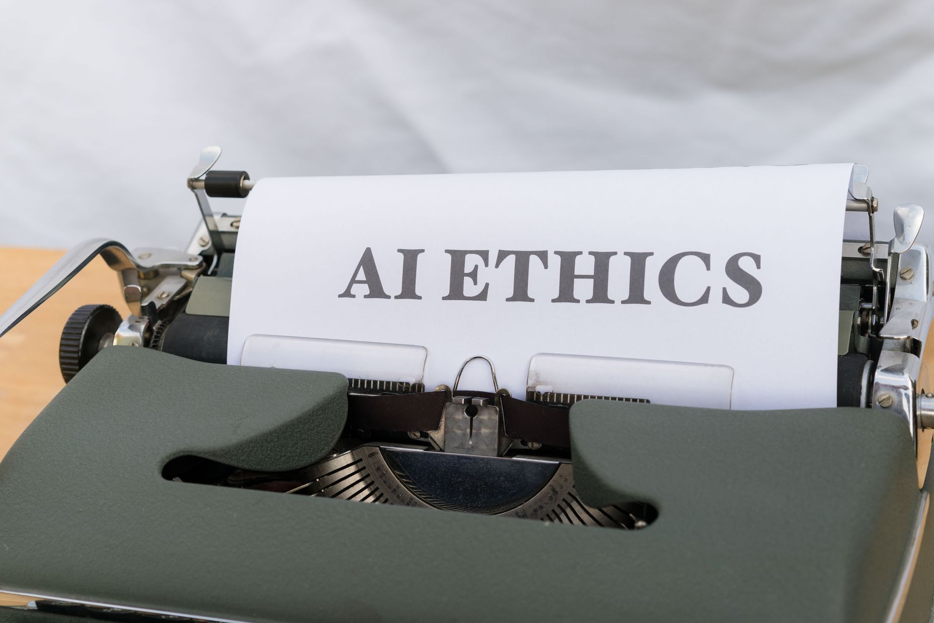 Zbliżenie na zabytkową maszynę do pisania i kartkę z napisem AI ethics